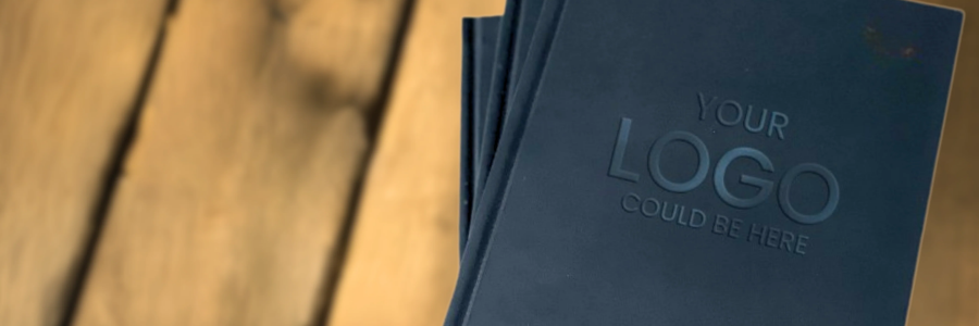 black diary with 'Your Logo Could Be Here' text on a wooden surface