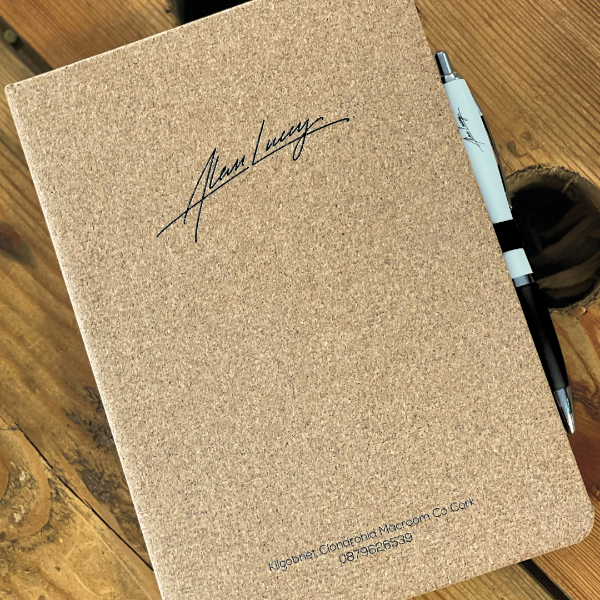 Cork notebook with a pen on a wooden surface