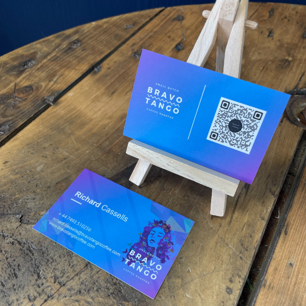 Blue business cards with 'Bravo Tango' branding on a wooden surface