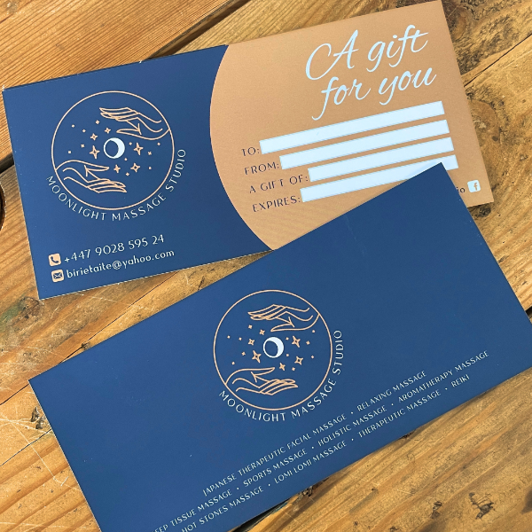 Blue gift voucher with Moonlight Massage Studio logo on a wooden surface