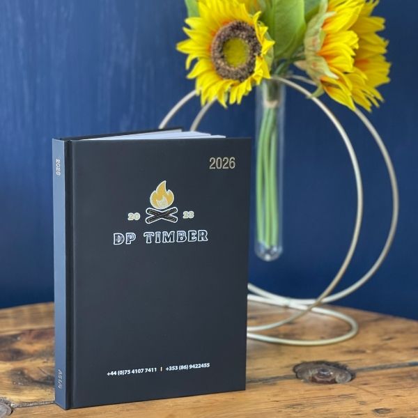 2026 Branded Diaries with DP Timber Logo UV Printed on the Cover on a wooden table with a sunflower