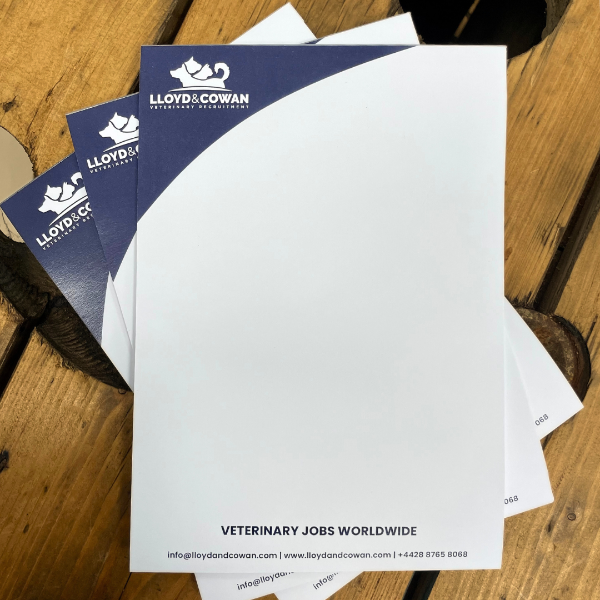 Lloyd & Cowan veterinary job notepads on a wooden surface