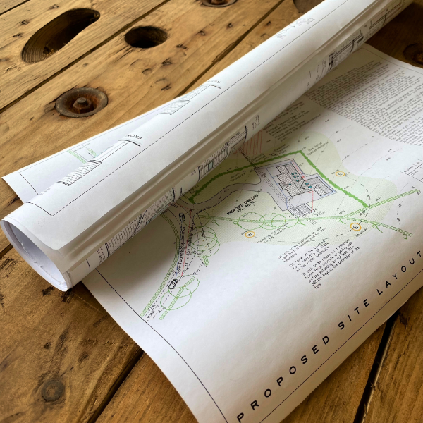 Rolled-up architectural plan on a wooden surface