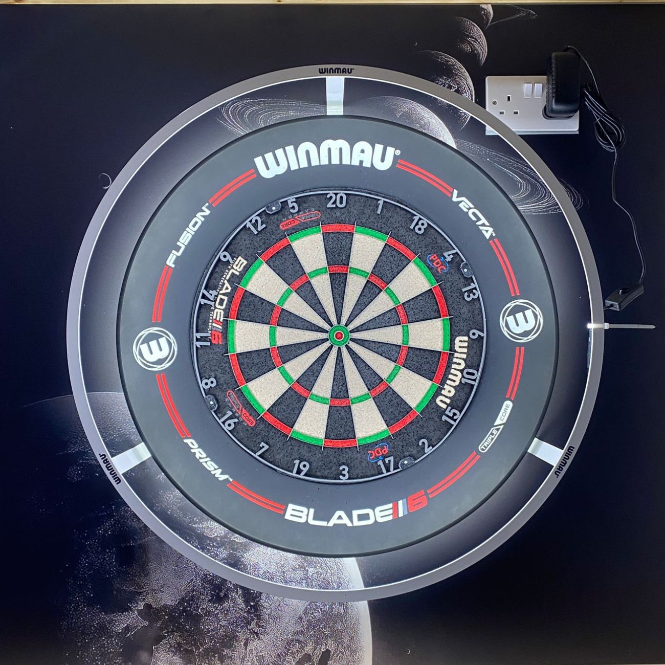 Winmau dartboard with branding on a protective ridge background