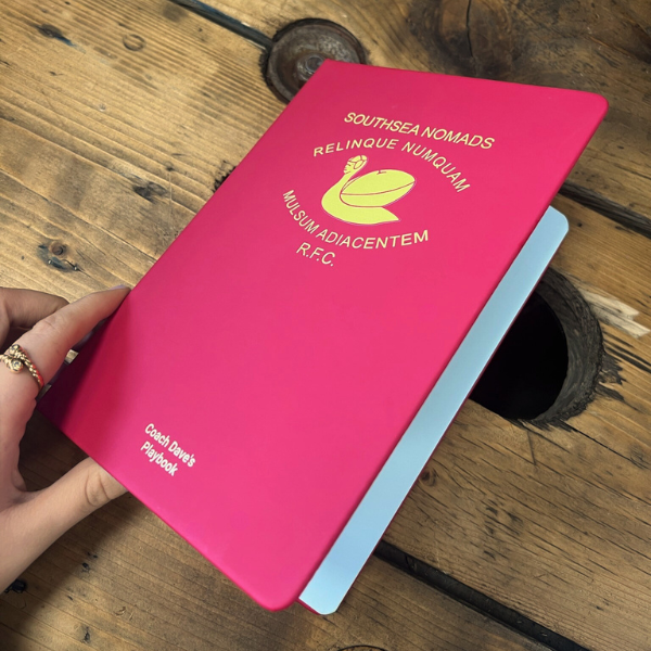 Red and yellow A5 notebook opening on wooden table