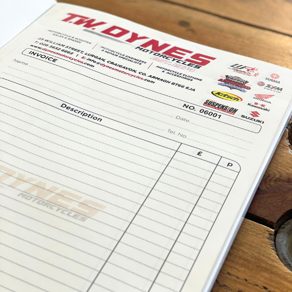 Invoice form for TW Dynes Motorcycles on a wooden surface
