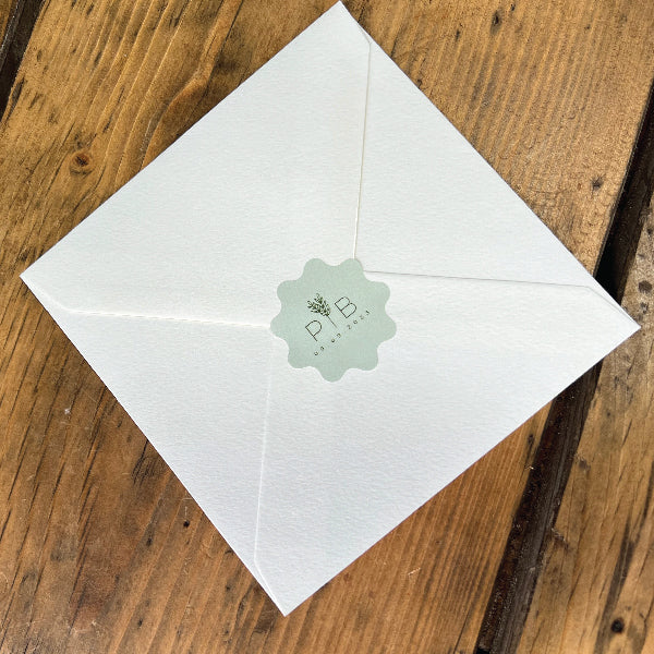 Light Green Custom Shape Wedding Stickers on the back of a Textured Envelop