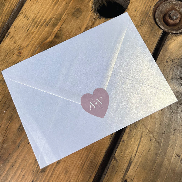 Pink Heart Shaped Wedding Sticker with the initials AV, on the back of an ivory pearlescent envelop