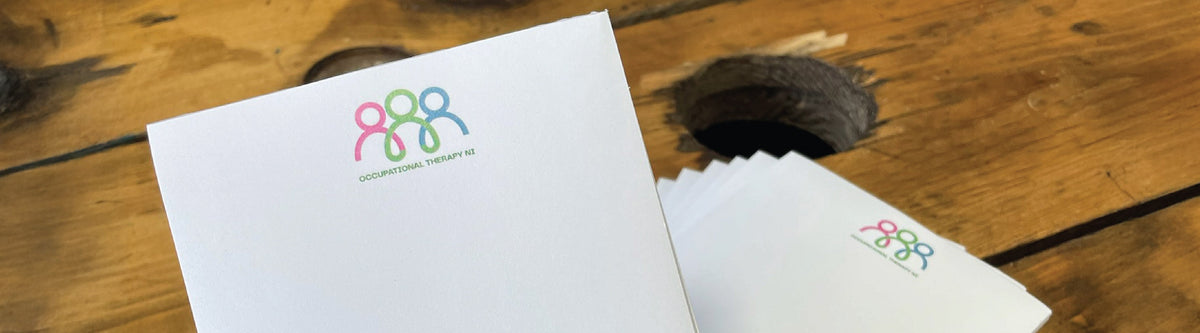 custom notepad with Coosters logo, on a wooden table