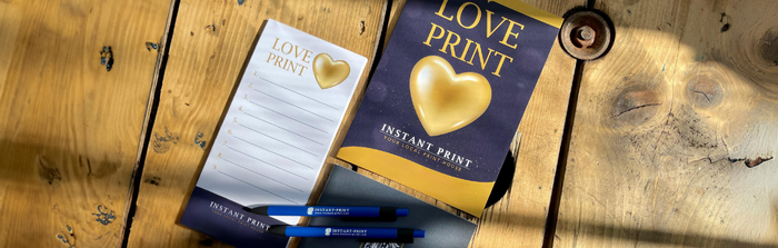 Instant Print Notepad, Pen and Booklet on Wooden Table