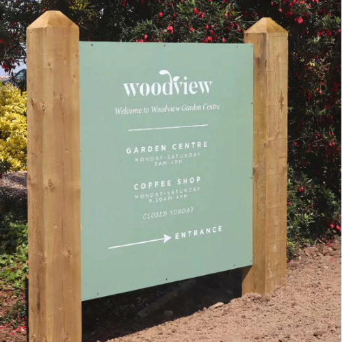 Woodview Garden Centre sign with wooden posts and plants in the background