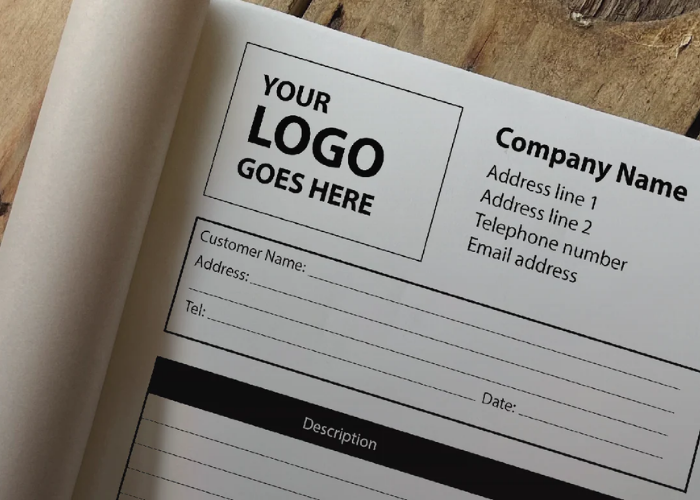 Blank label with space for a logo and contact information in invoice book on a wooden surface