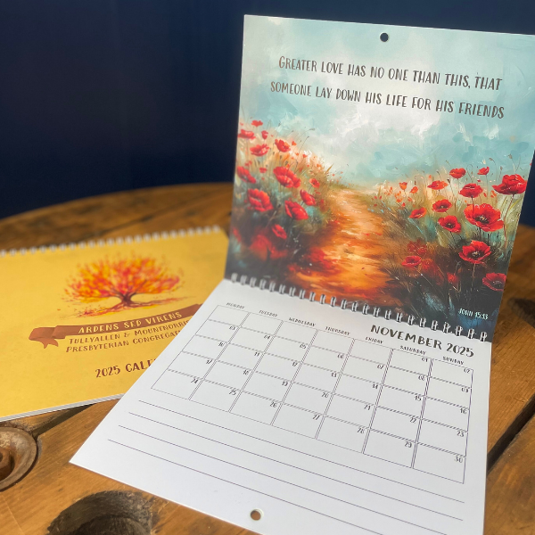 Calendar with a painting of a path with red flowers on a wooden surface