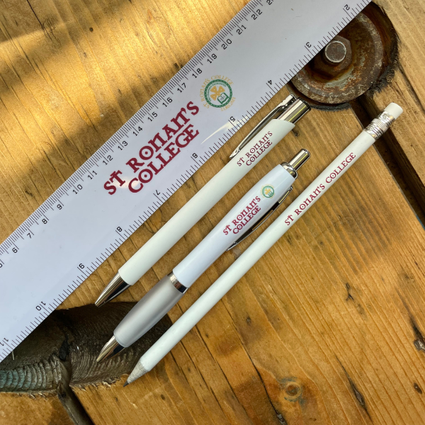 Branded Rulers, Pens and Pencils for St Ronan's College on a wooden table.