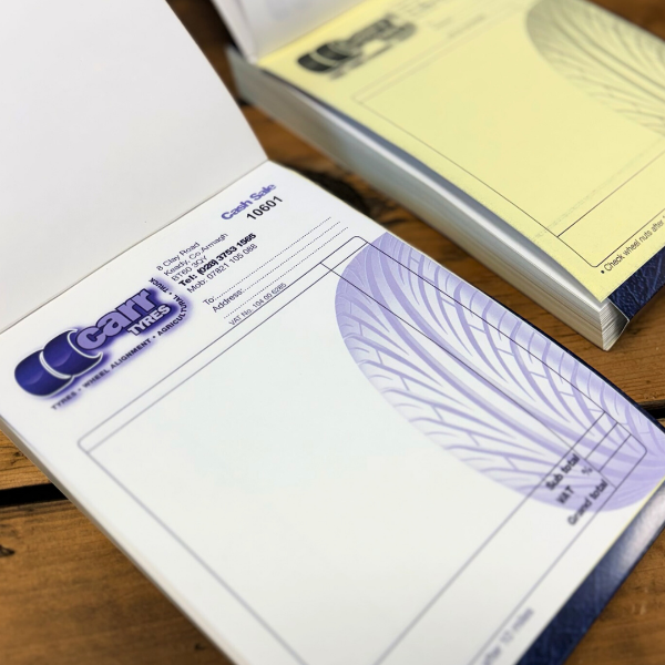 2 Duplicate Invoice Books on wooden table