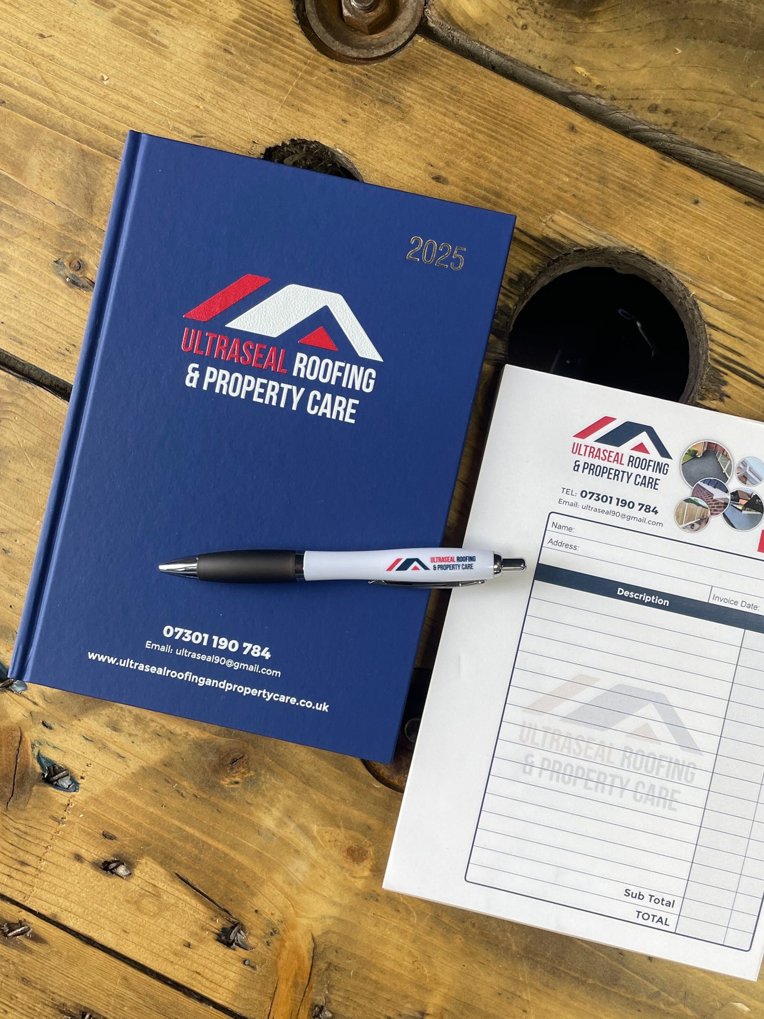 Blue Diary with Ultra Safe Roofing & Property Care branding on a wooden surface.