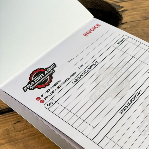 Invoice pad with Frazer Agri logo on a wooden surface