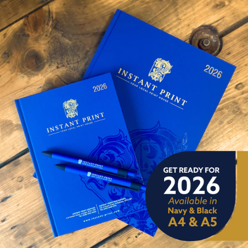 Two blue notebooks with 'Instant Print' branding on a wooden surface, accompanied by promotional text.