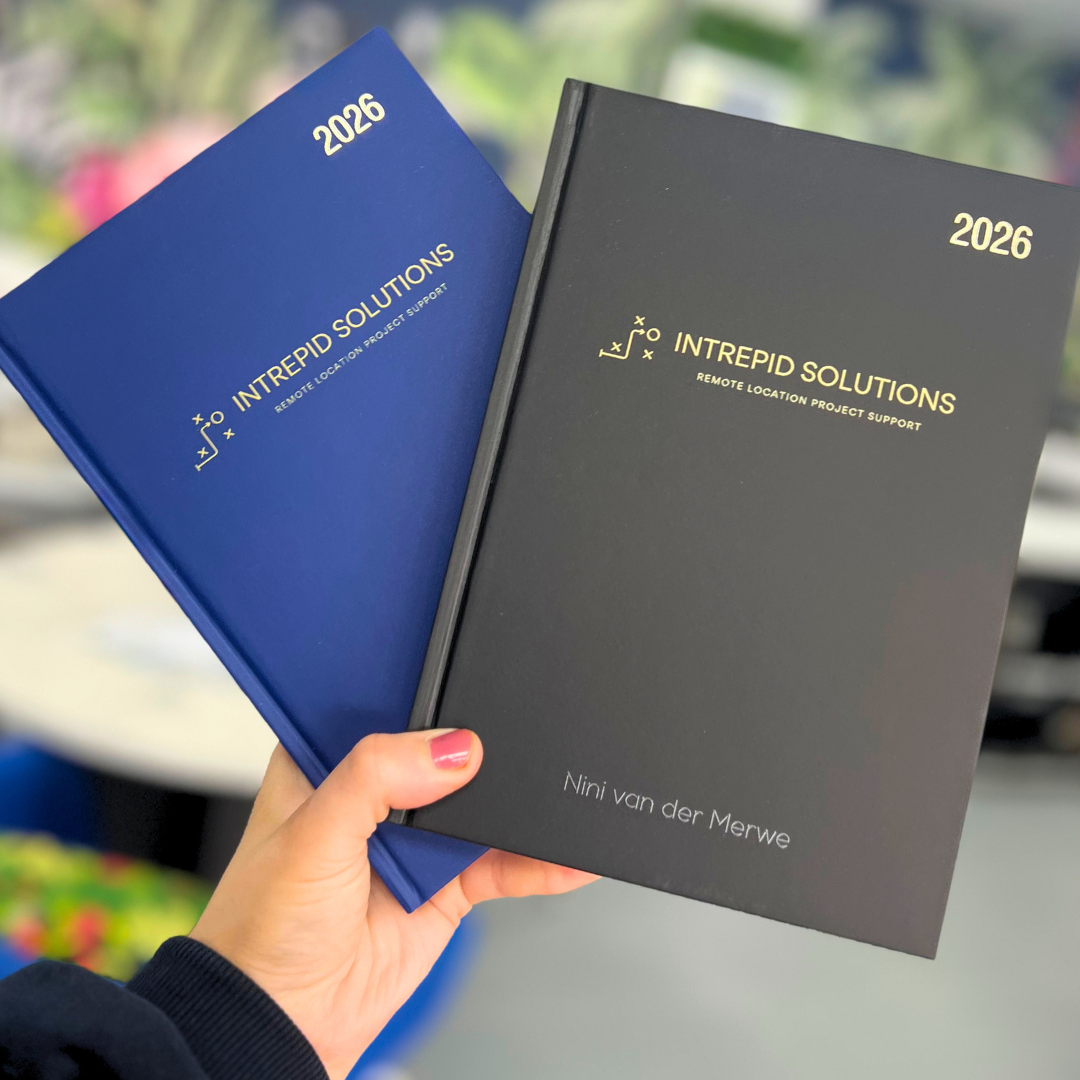 Two 2026 diaries from Intrepid Solutions held by a hand with a blurred background