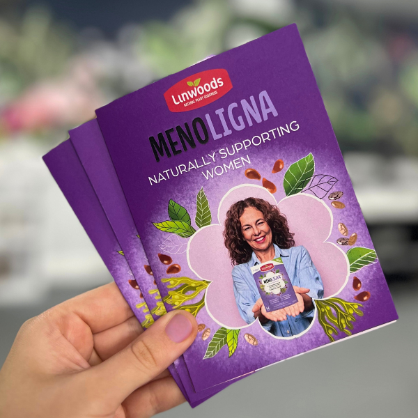Purple book titled 'Menoligna' held by a hand with a blurred background
