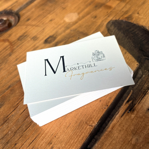 Stack of Markethill Fragrances business cards on a wooden surface