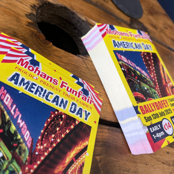 Two Mohans' Funfair American Day flyers on a wooden surface