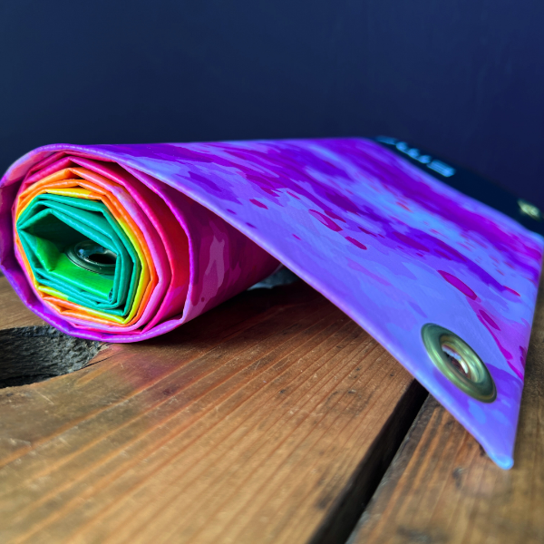 Multicolour pvc banner rolled up on wooden surface