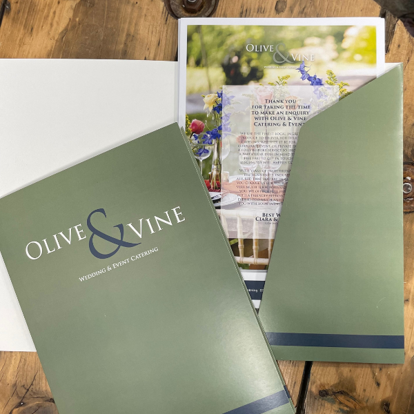 Olive & Vine wedding and event catering materials on a wooden surface