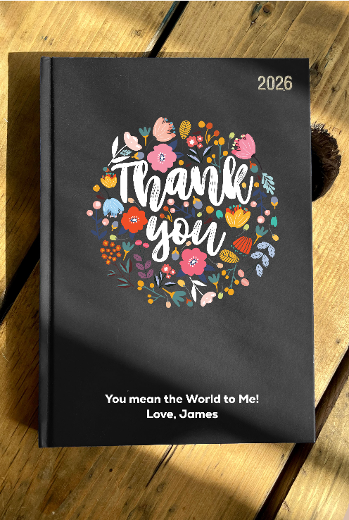 Black Diary 2026 with floral design and text on a wooden surface