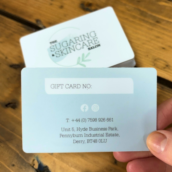 Blue and white plastic gift cards on wooden table