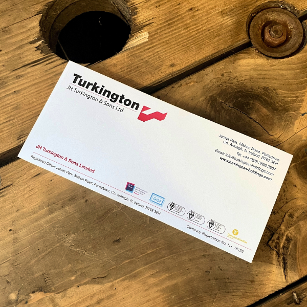 Turkington JH & Sons Ltd compliment slip on a wooden surface