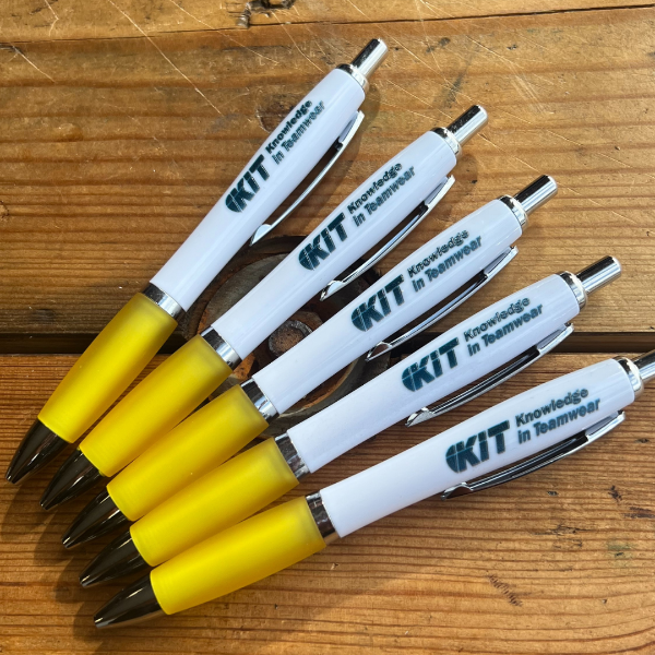 Set of pens with yellow barrels and white bodies on a wooden surface