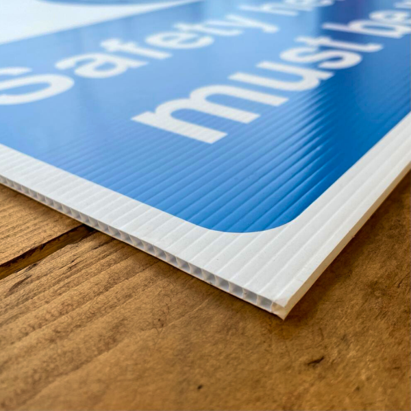 Close-up of a blue and white correx sign on a wooden surface
