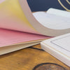 Triplicate Invoice Book pages flicking through on wooden tables