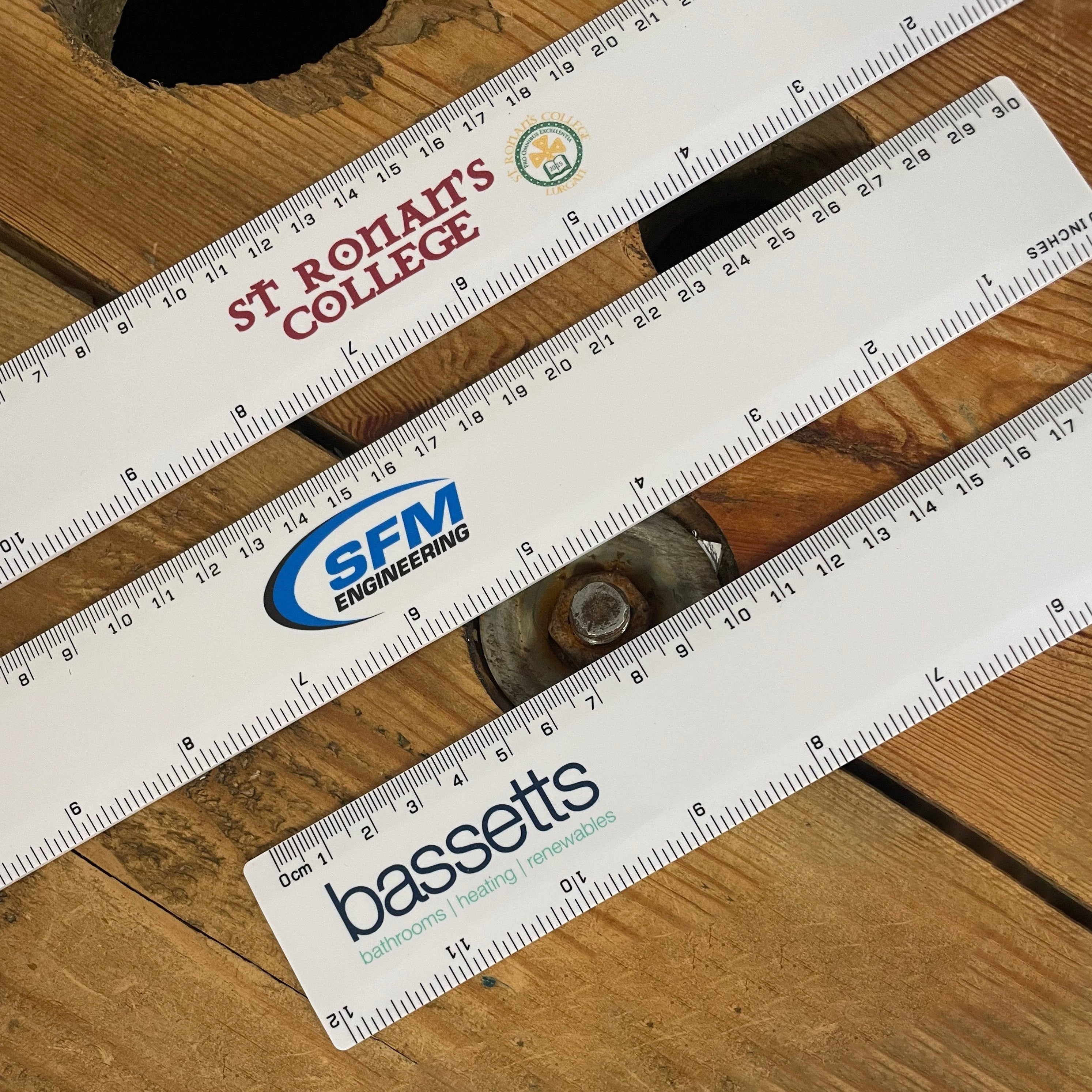 3 Rulers laid out on wooden table